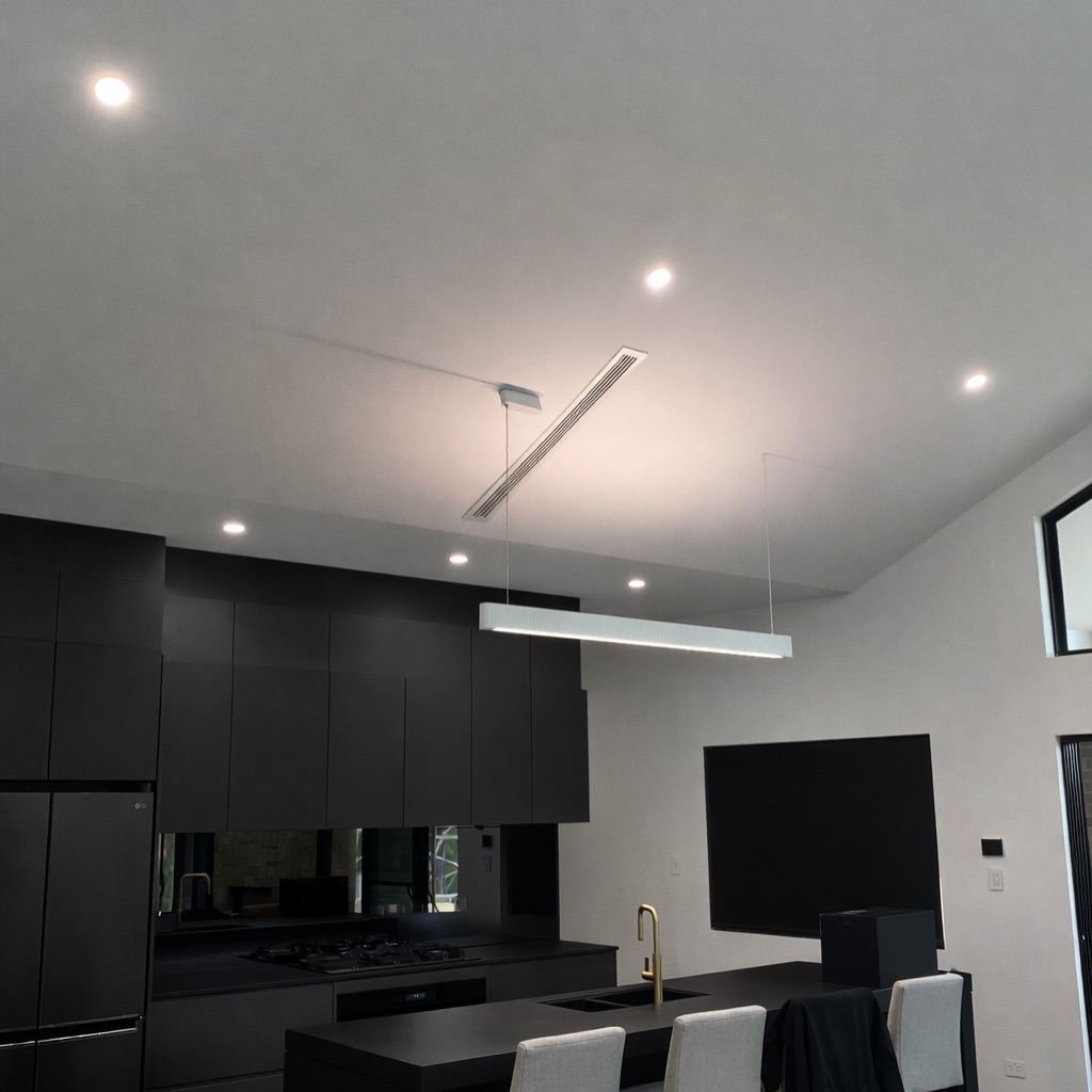 Matte black kitchen with downlights and linear pendant